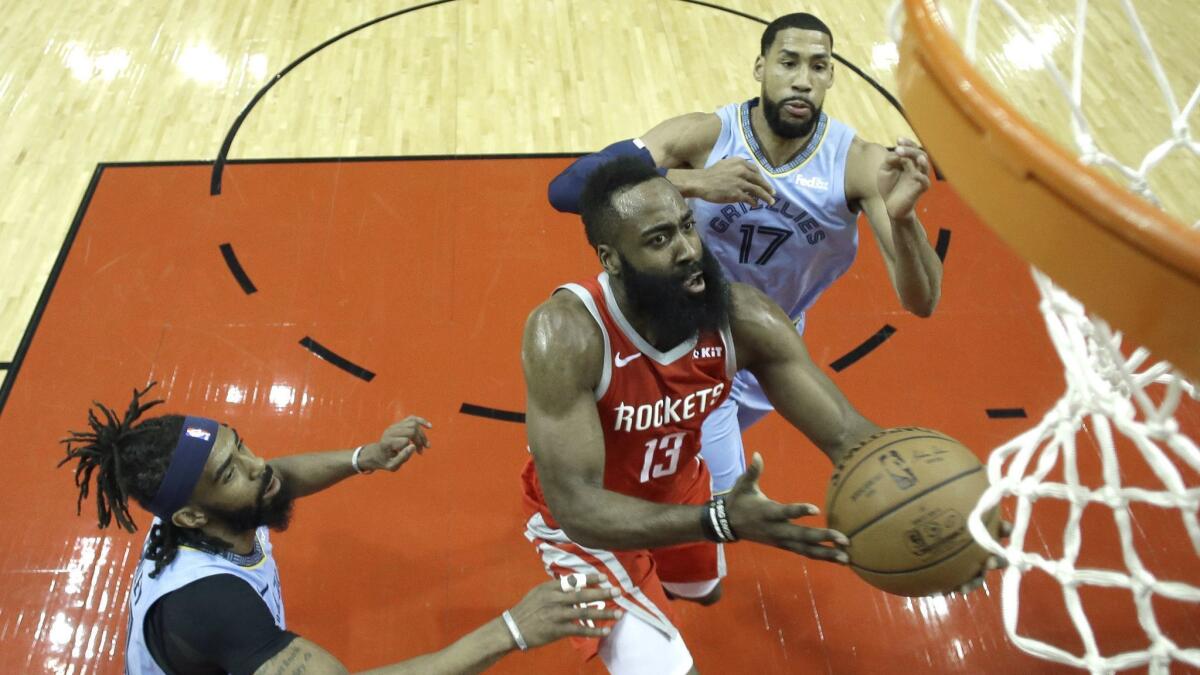 Houston Rockets' James Harden (13) goes up for a shot as Memphis Grizzlies' Garrett Temple (17) and Mike Conley defend.