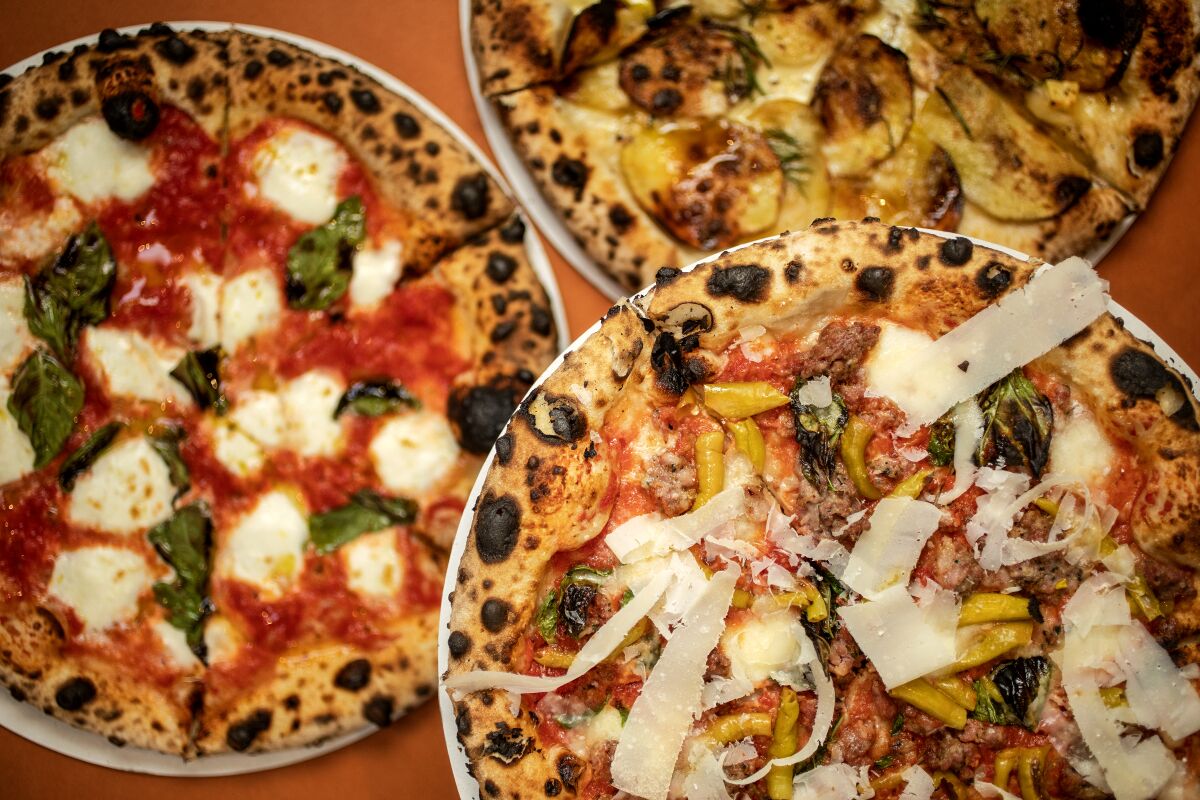 overhead view of three pizza pies