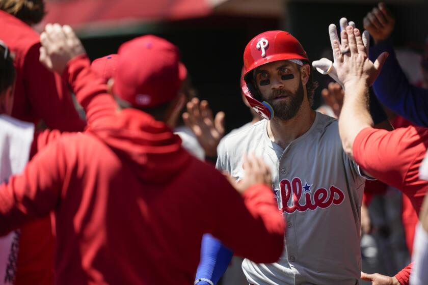 Philadelphia Phillies' Bryce Harper celebrates in the dugout after hitting a two-run homer in the third inning of a baseball game against the Cincinnati Reds on Thursday, April 25, 2024, in Cincinnati. (AP Photo/Carolyn Kaster)