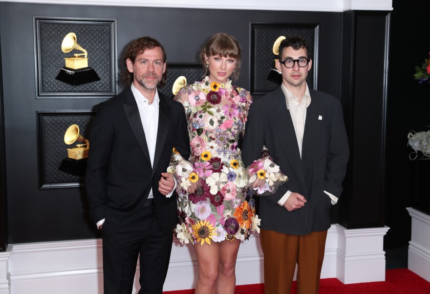 Two men and a woman on the red carpet at the Grammy Awards