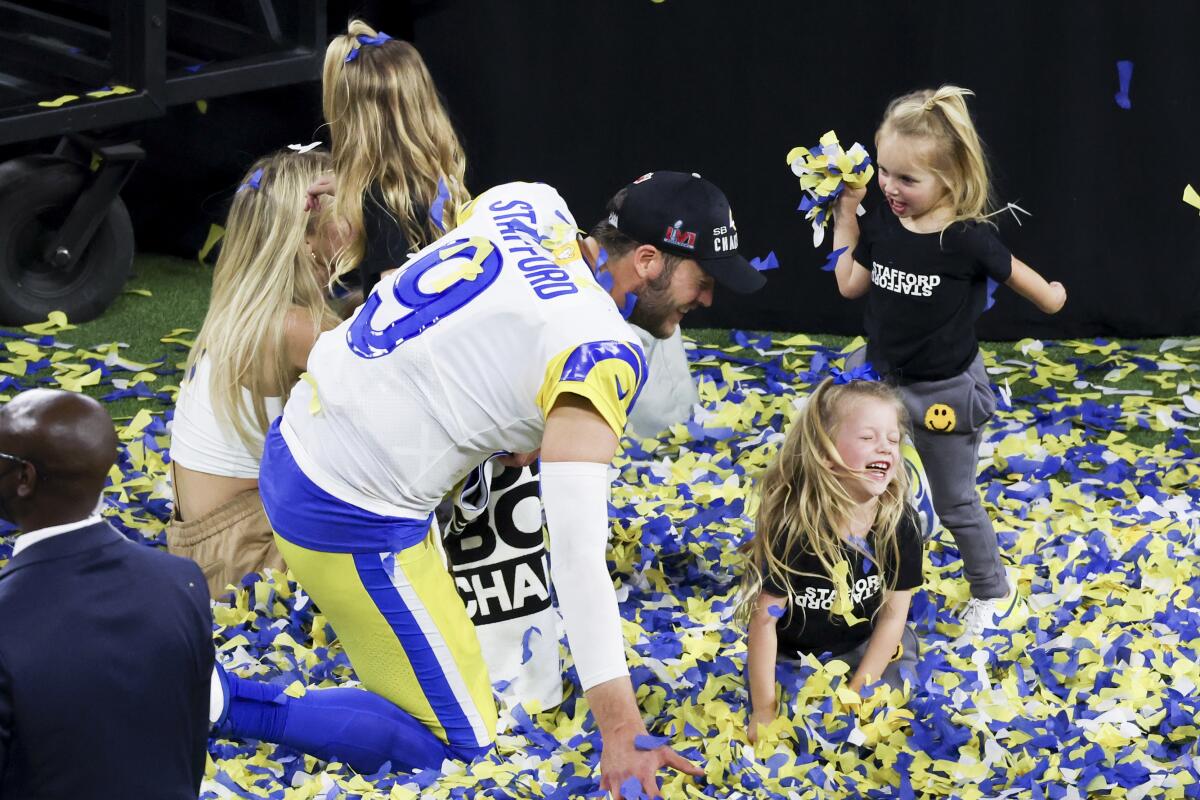 Rams quarterback Matthew Stafford celebrates with his daughters on the field after winning the Super Bowl.