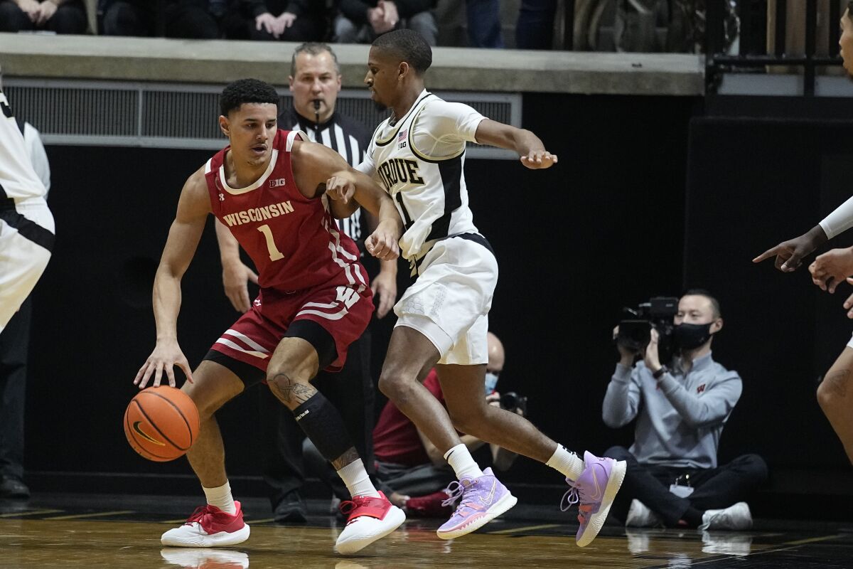 Wisconsin's Johnny Davis (1) is defended by Purdue's Isaiah Thompson (11) during the second half of an NCAA basketball game, Monday, Jan. 3, 2022, in West Lafayette, Ind. (AP Photo/Darron Cummings)