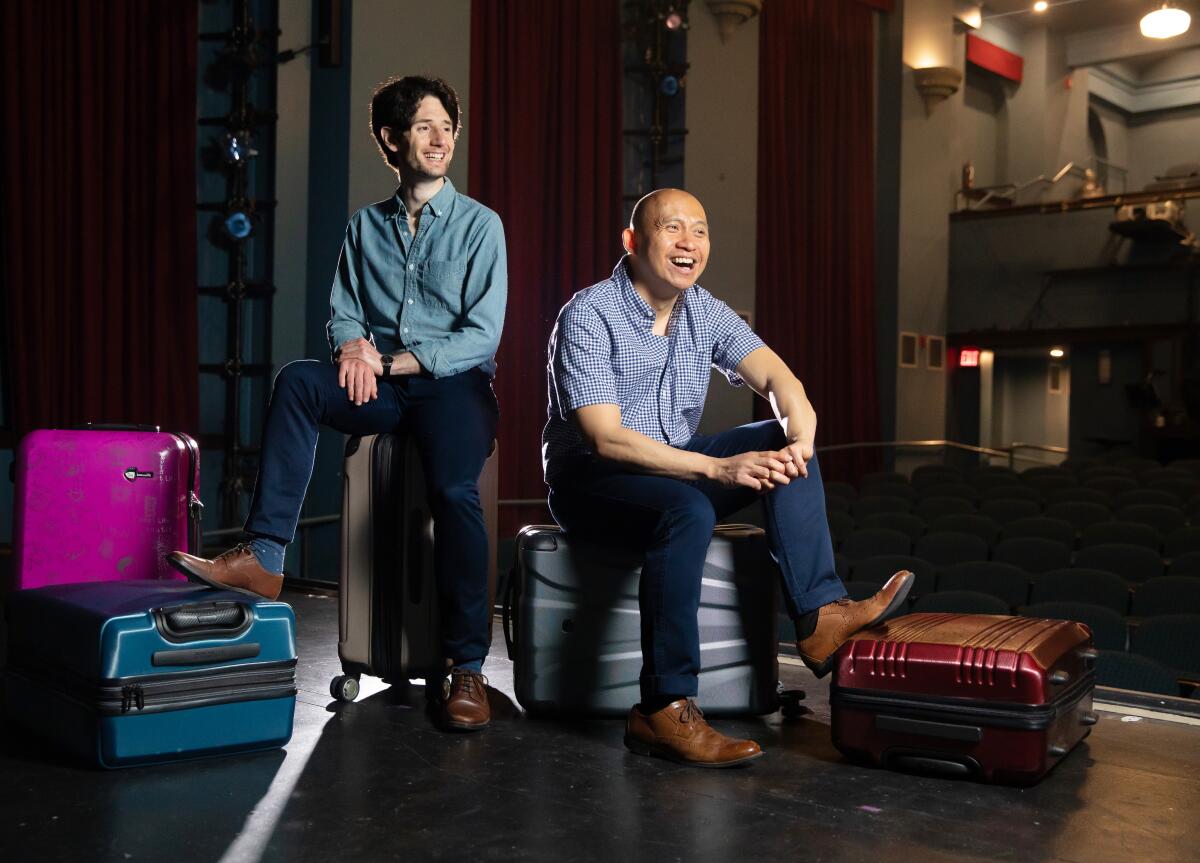 Noam Shapiro and Paulo K Tiról rest their feet on suitcases onstage.