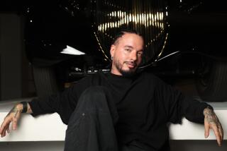 Singer J Balvin poses for a portrait in front of a 1925 Rolls-Royce Phantom at the Petersen Automotive Museum.