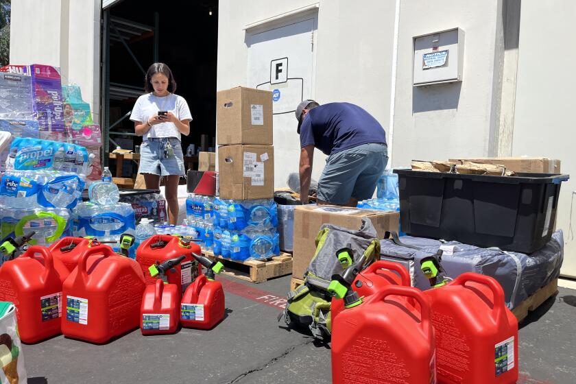 Kati Kai Engle and Lake Casco prepare three pallets of relief aid for the wildfires in Maui.