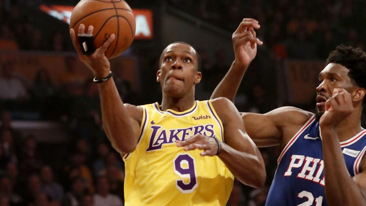 Lakers guard Rajon Rondo drives to the basket against 76ers center Joel Embiid during a game last season.