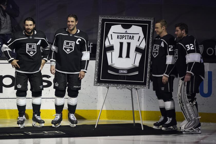 Los Angeles Kings center Anze Kopitar, center, poses for pictures with defenseman Drew Doughty, left, right wing.