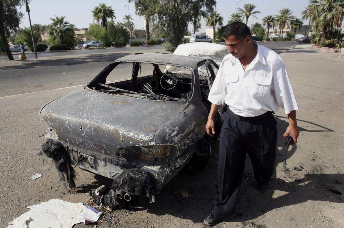 An Iraqi traffic policeman inspects a car destroyed by a Blackwater security detail in Nisoor Square in Baghdad in 2007.
