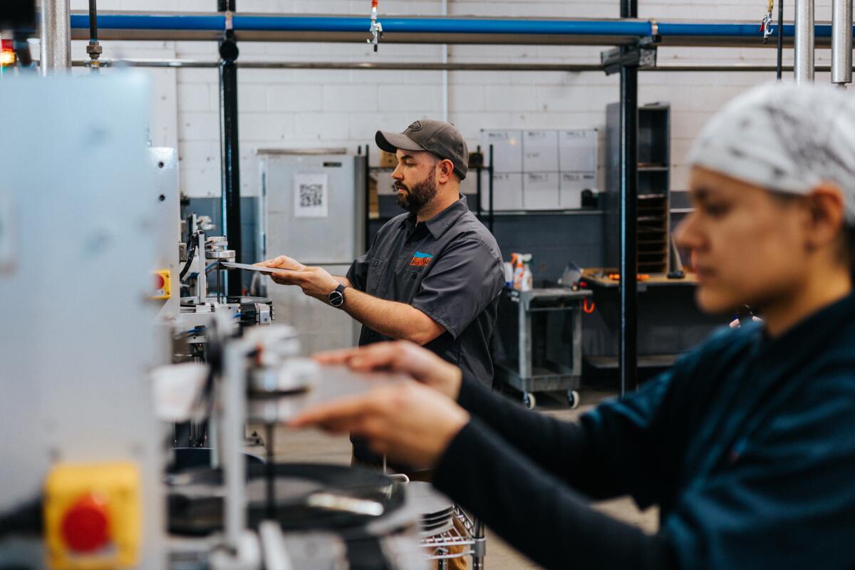 Workers making records at a vinyl pressing plant.