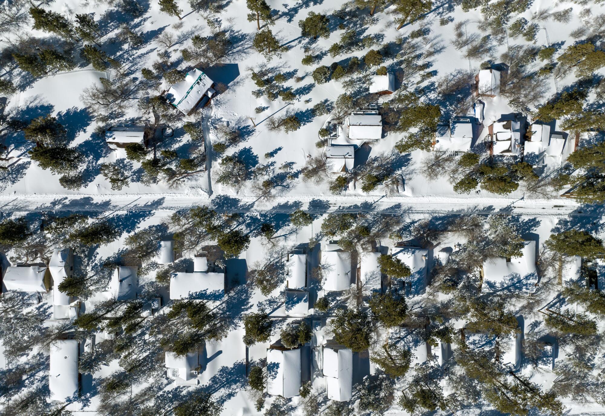 An aerial view of homes in Big Bear Valley covered in snow 