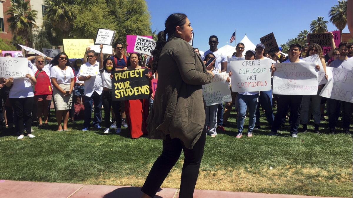 More than 200 supporters of three University of Arizona students who were charged after protesting the presence of Border Patrol agents on campus last month staged a protest in Tucson on April 10.