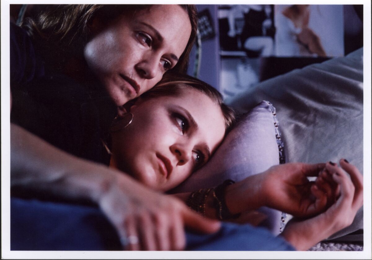 Eine Frau und ihre Tochter liegen auf einem Bett.