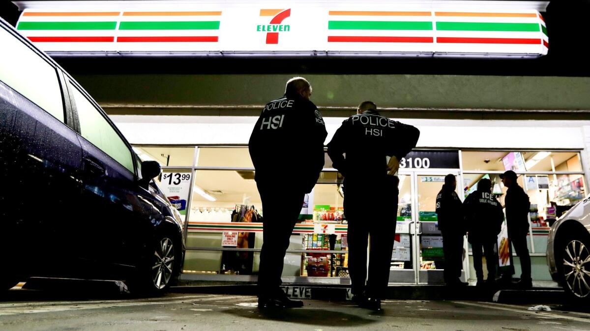 U.S. Immigration and Customs Enforcement agents serve an employment audit notice at a 7-Eleven convenience store last week in Los Angeles.