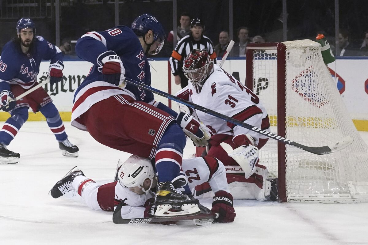 Carolina Hurricanes defenseman Brett Pesce (22) dives to stop an attempt by New York Rangers left wing Chris Kreider (20) on the goal during the second period of an NHL hockey game Tuesday, April 12, 2022, in New York. (AP Photo/Bebeto Matthews)