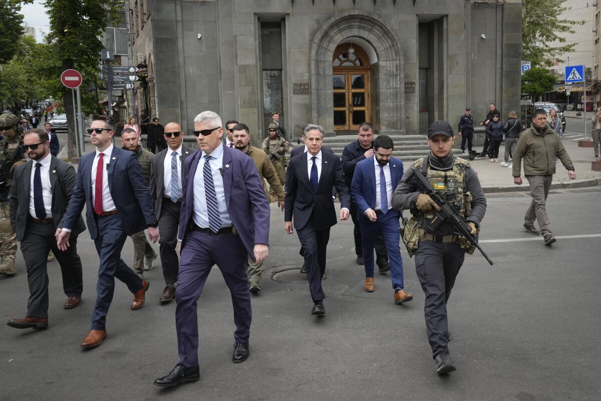 Secretary of State Antony J. Blinken, surrounded by security officers, walks in Independence Square in Kyiv, Ukraine.