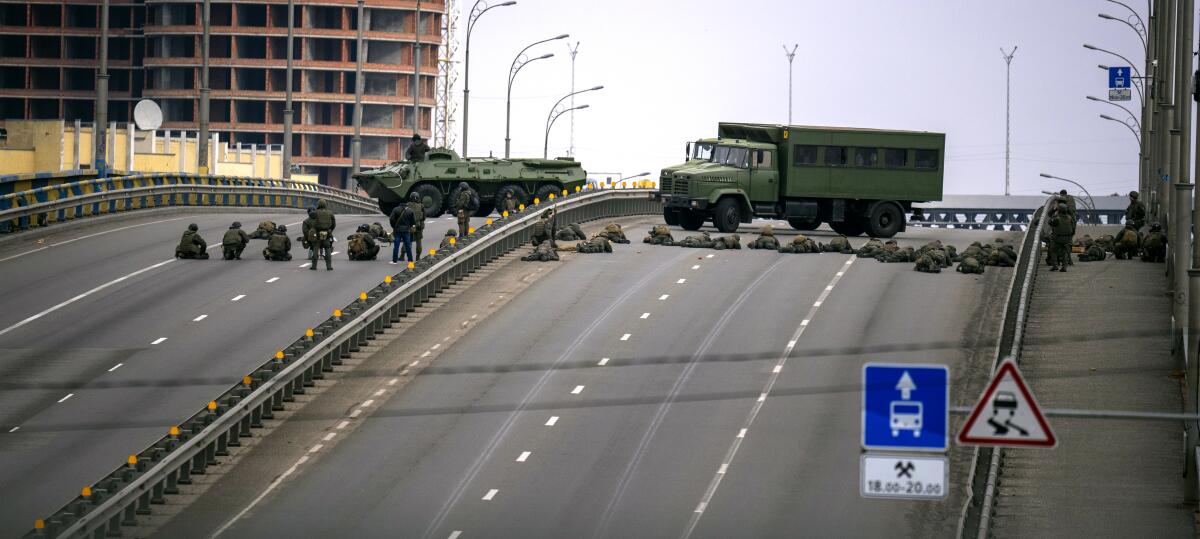 Ukrainian soldiers across a bridge roadway 