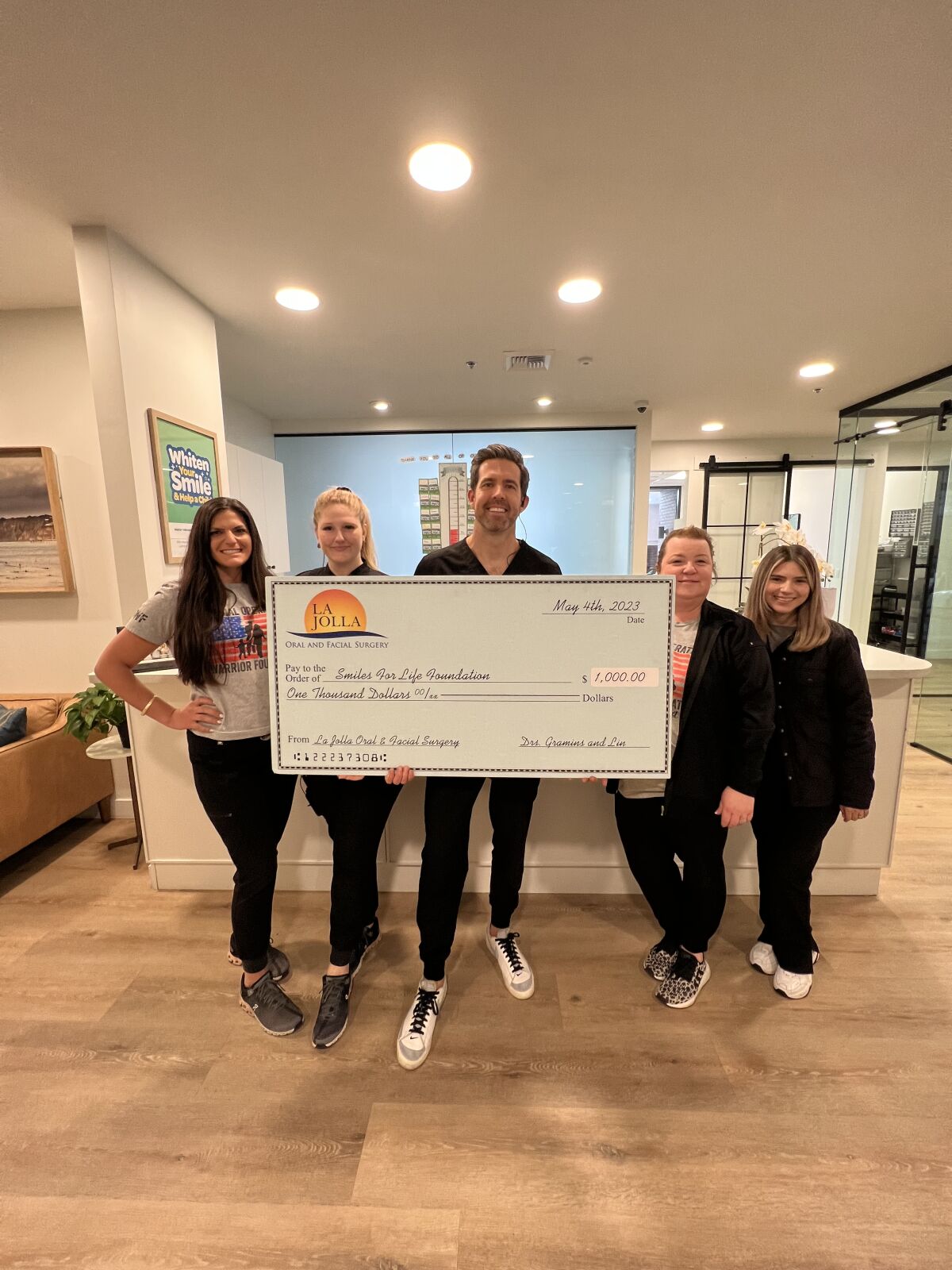 Dentist Weston Spencer and staff show a donation check from La Jolla Oral and Facial Surgery for Spencer's charity campaign.