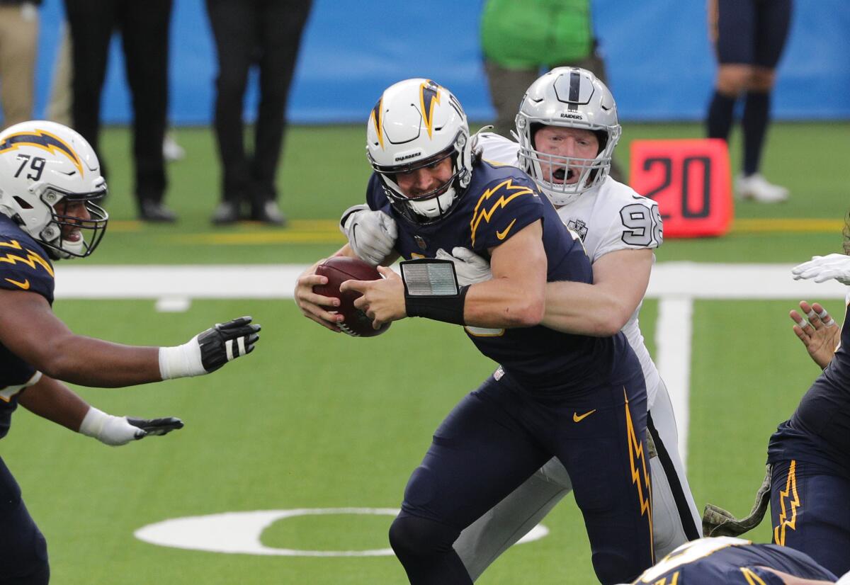 Raiders defensive end Maxx Crosby sacks Chargers quarterback Justin Herbert during the first half Sunday.