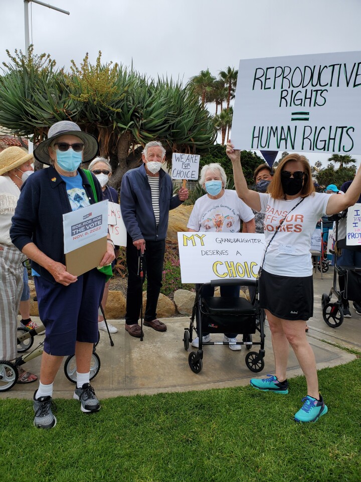 Casa de Mañana residents and supporters hold signs in support of reproductive rights during a protest July 10 in La Jolla.