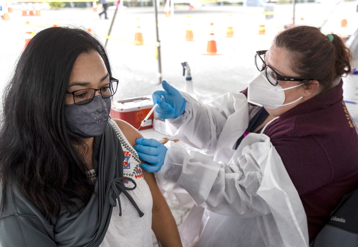 A woman gets a COVID-19 vaccine in Riverside.