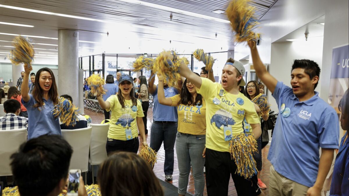 Students and staff cheer on a student after he completes his intent to enroll at UCLA during Bruins Day, when the school welcomes to campus all admitted students.