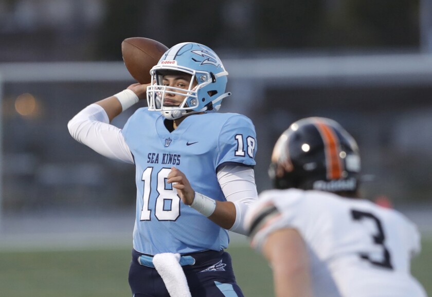 Corona del Mar quarterback David Rasor (18) throws a completion against Huntington Beach on Friday night.