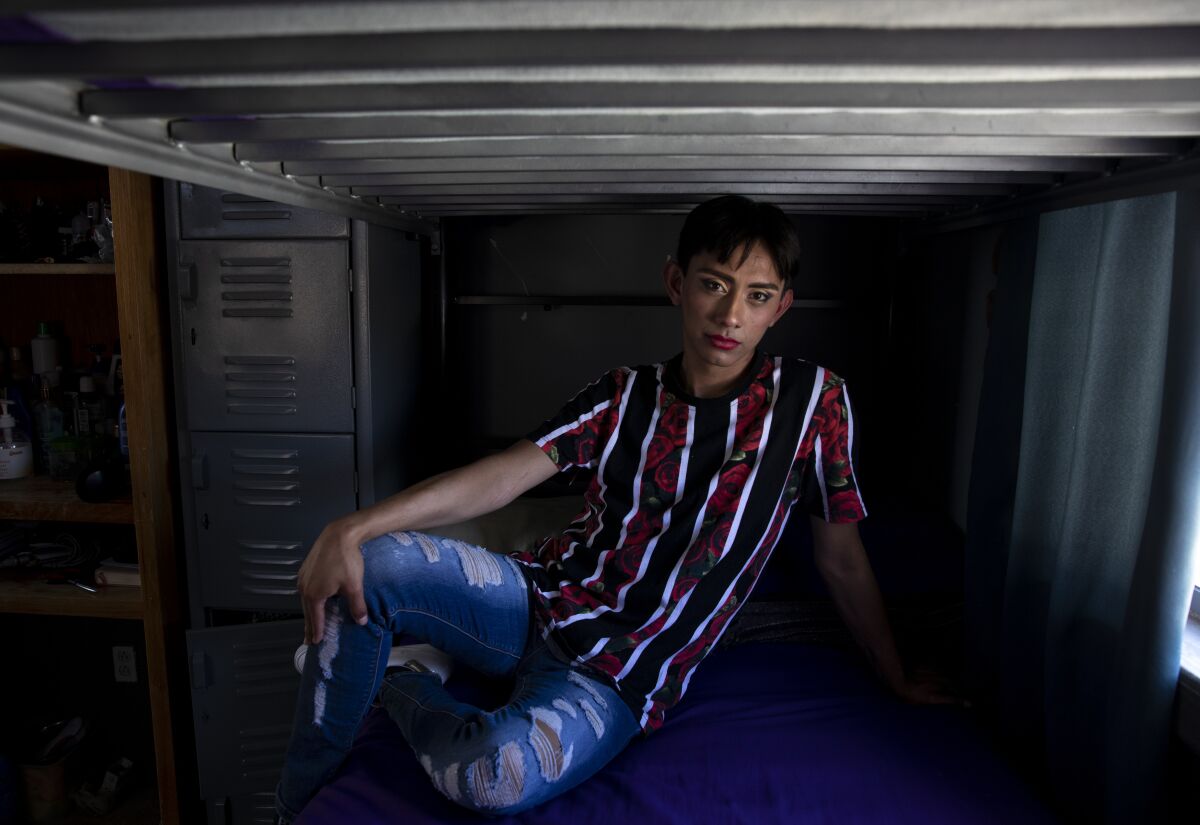 José Geovanny Torres Morataya sits on a bunk bed at the migrant shelter where she lives