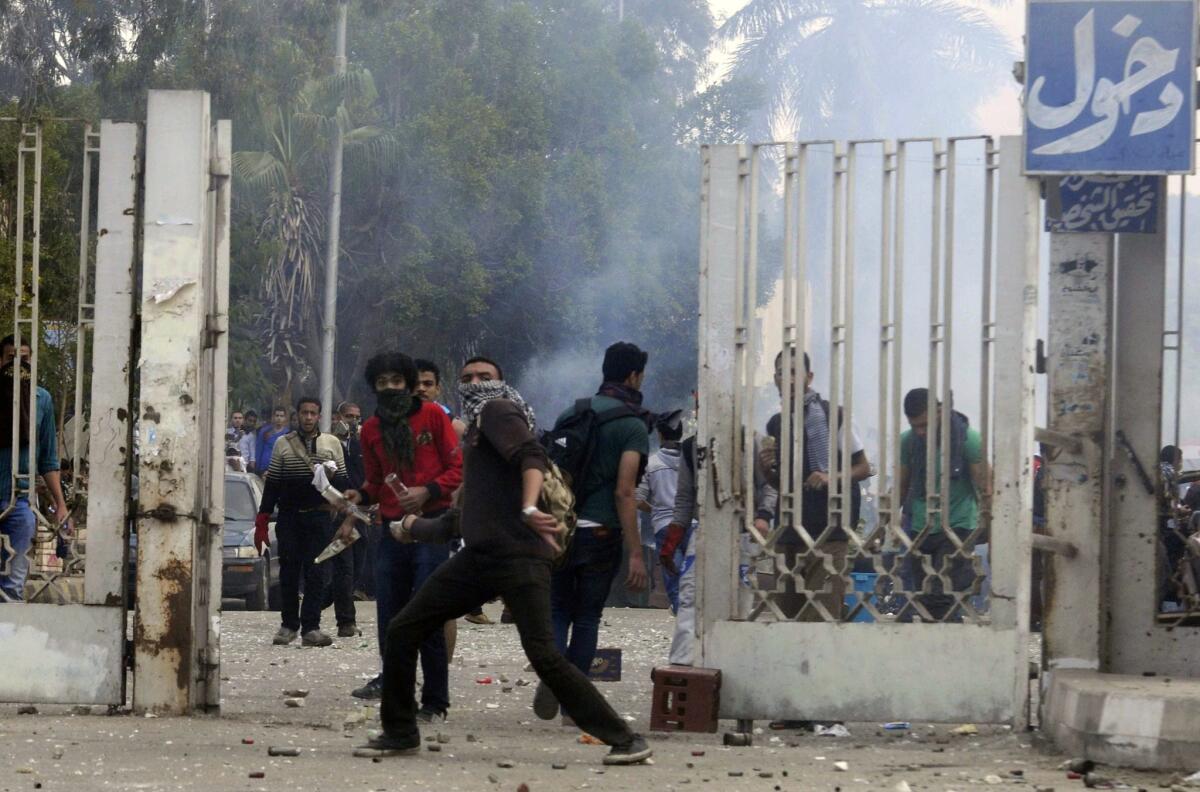Al Azhar University students who support Egypt's Muslim Brotherhood clash with riot police outside the school's Cairo campus Monday.