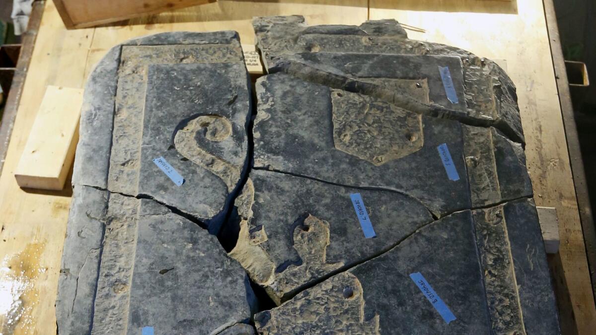 A portion of the 6-foot black stone slab rediscovered in the 1617 church is seen in historic Jamestown, Va.