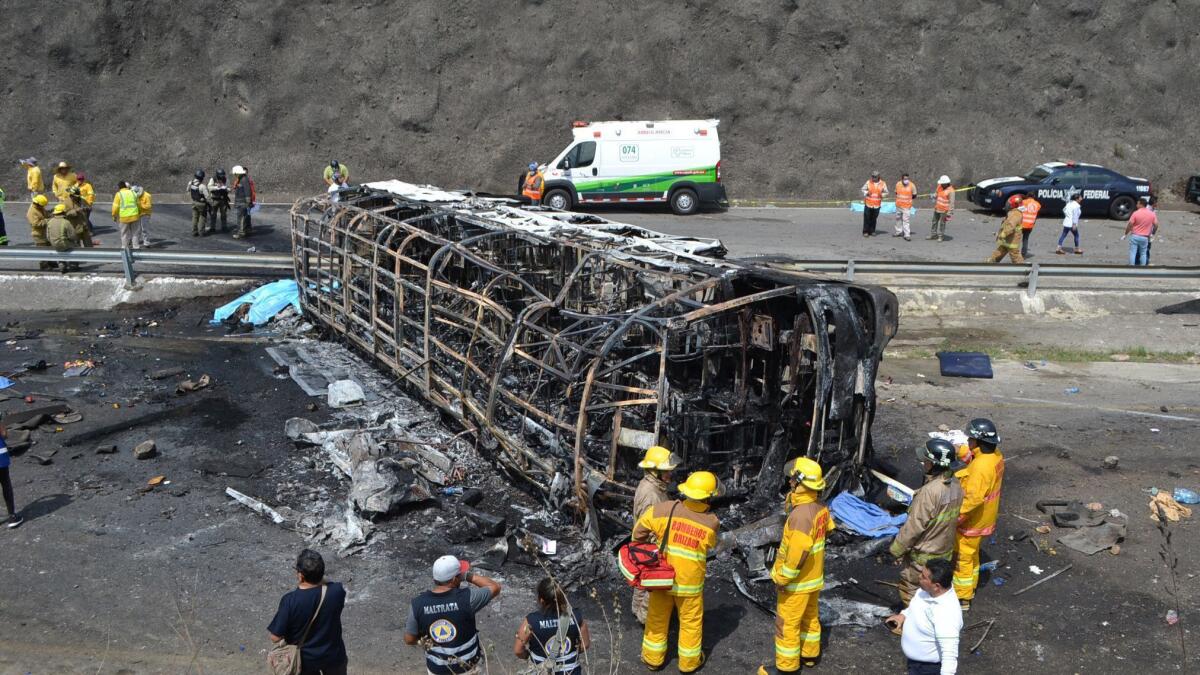Rescuers and firefighters work at the scene of a crash between a tour bus and a semi-trailer on a mountain road in Veracruz, Mexico, on Wednesday.