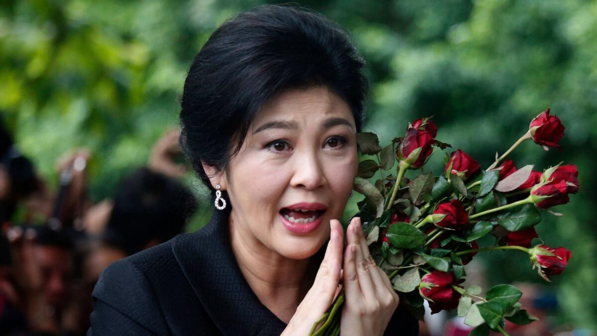 In this July 21, 2017, file photo, former Thai Prime Minister Yingluck Shinawatra greets supporters as she arrives at the Supreme Court to make her final statements in a trial on a charge of criminal negligence in Bangkok.