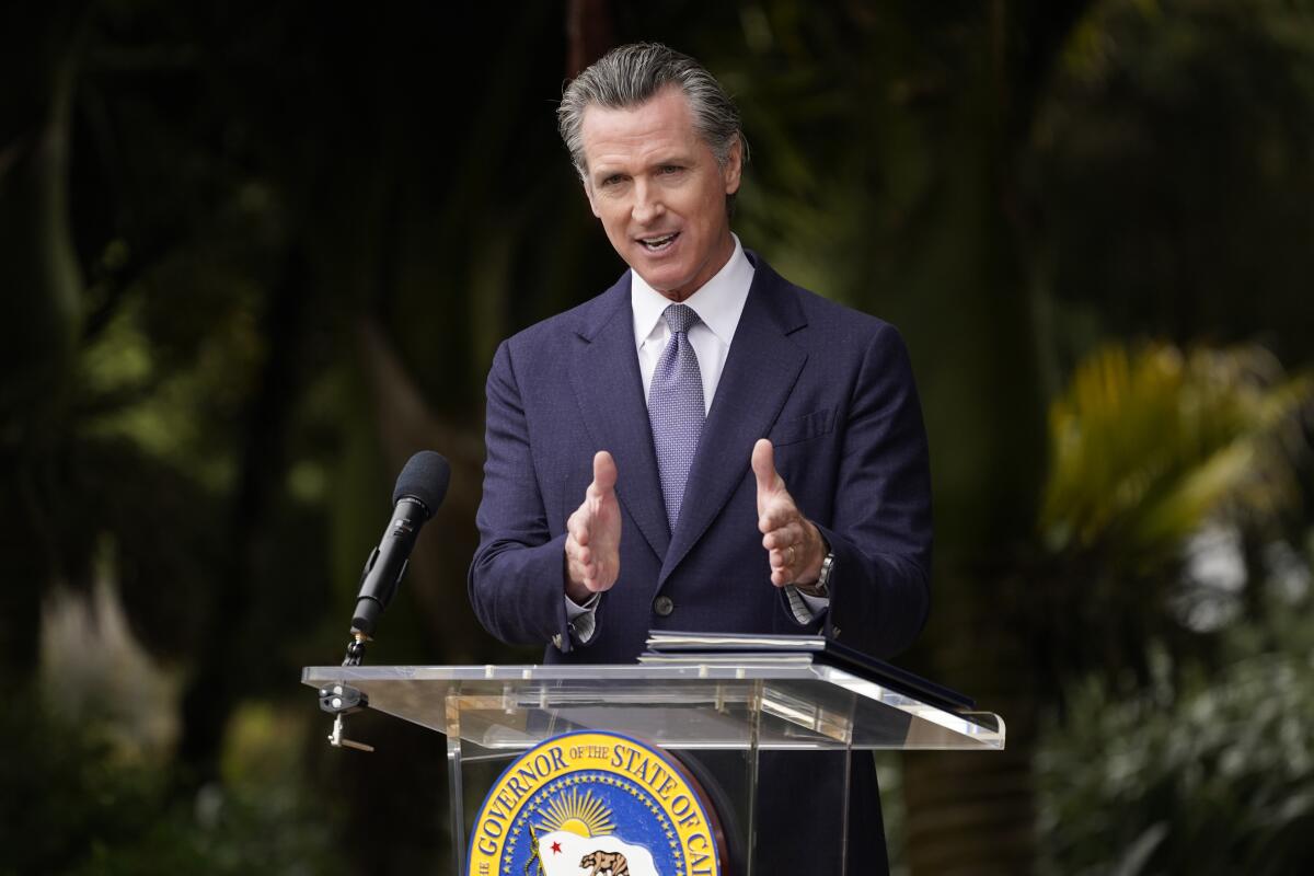 California Gov. Gavin Newsom speaks from a podium during an event at the San Francisco Botanical Garden in May
