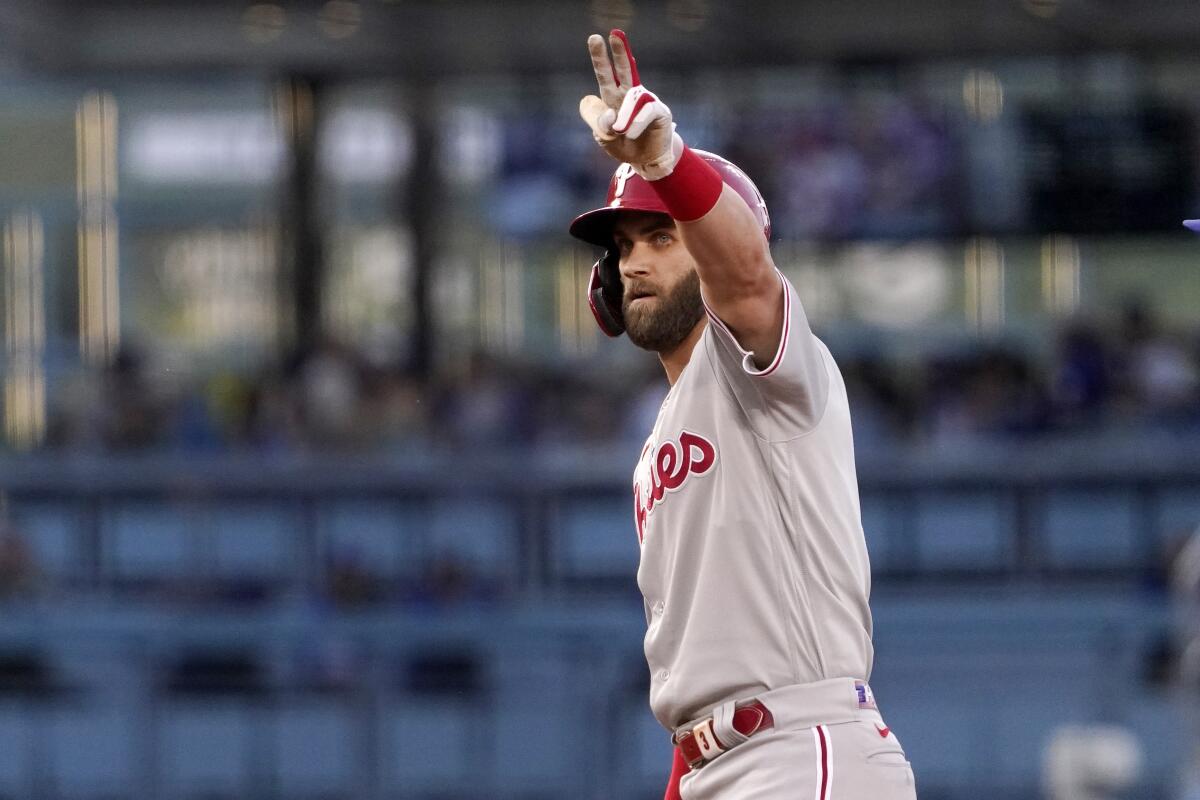 Philadelphia's Bryce Harper gestures toward his dugout after hitting a double during the first inning.