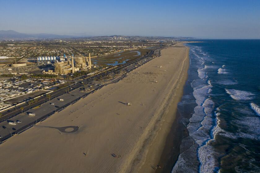 HUNTINGTON BEACH, CA - February 17: A view of the older AES Huntington Beach Power Station at left, and new one at right, and is the proposed site of the Poseidon Desalination Plant, which would draw ocean water through an existing intake pipe at Wednesday, Feb. 17, 2021 in Huntington Beach, CA. (Allen J. Schaben / Los Angeles Times)