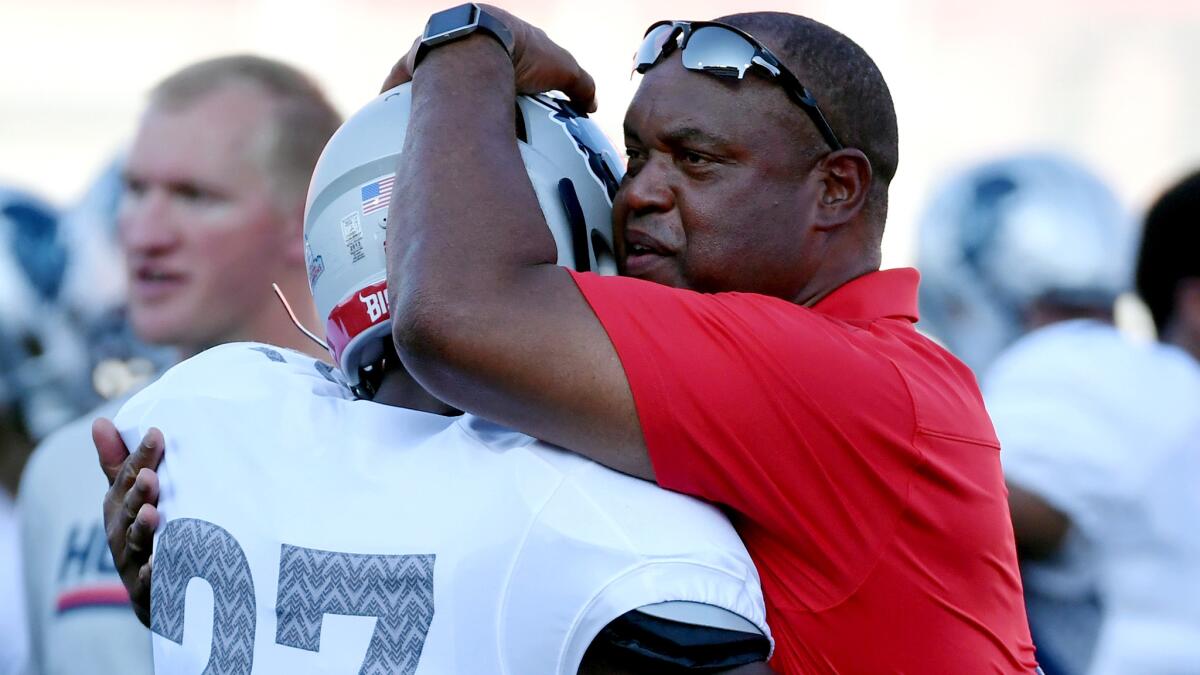 Howard coach Mike London embraces defensive back Aaron Walker before the start of their game against UNLV on Saturday night.