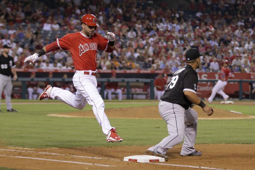 Third baseman Kaleb Cowart tries to beat out a throw to White Sox first baseman Jose Abreu in his first game with the Angels.