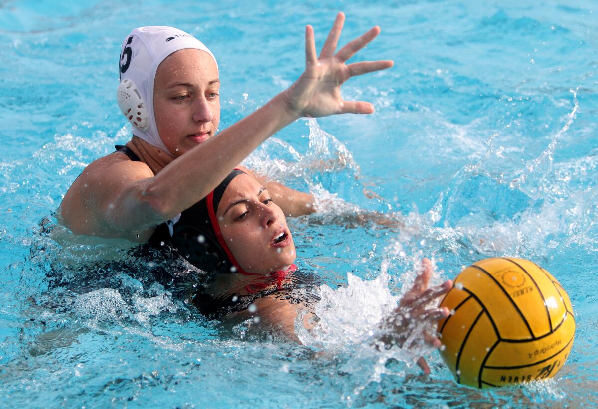 Flintridge Sacred Heart Academy water polo player Bree Layseca tries to get a hold of the ball under pressure from Sophie Wazzan in home game vs. Marymount, in La Canada Flintridge on Thursday, Jan. 30, 2020.