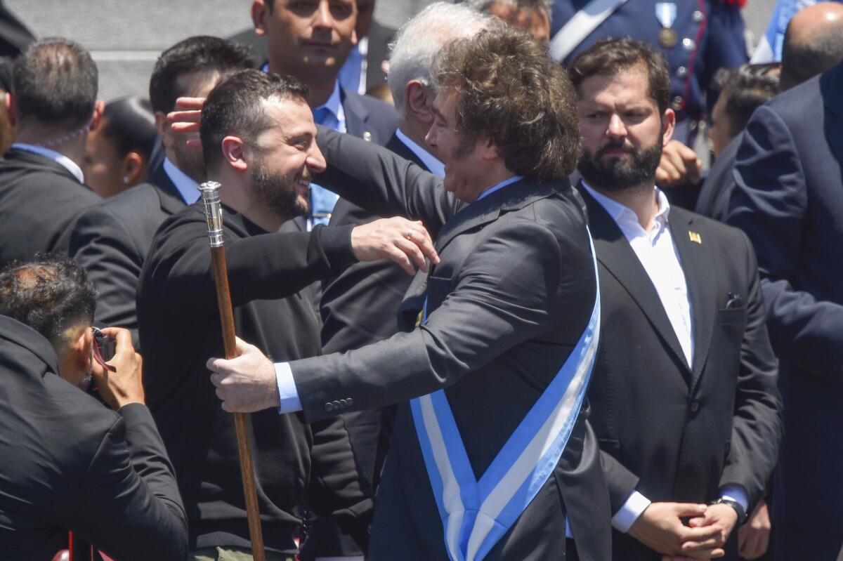 Ukrainian President Volodymyr Zelensky embracing Argentina's new President Javier Milei