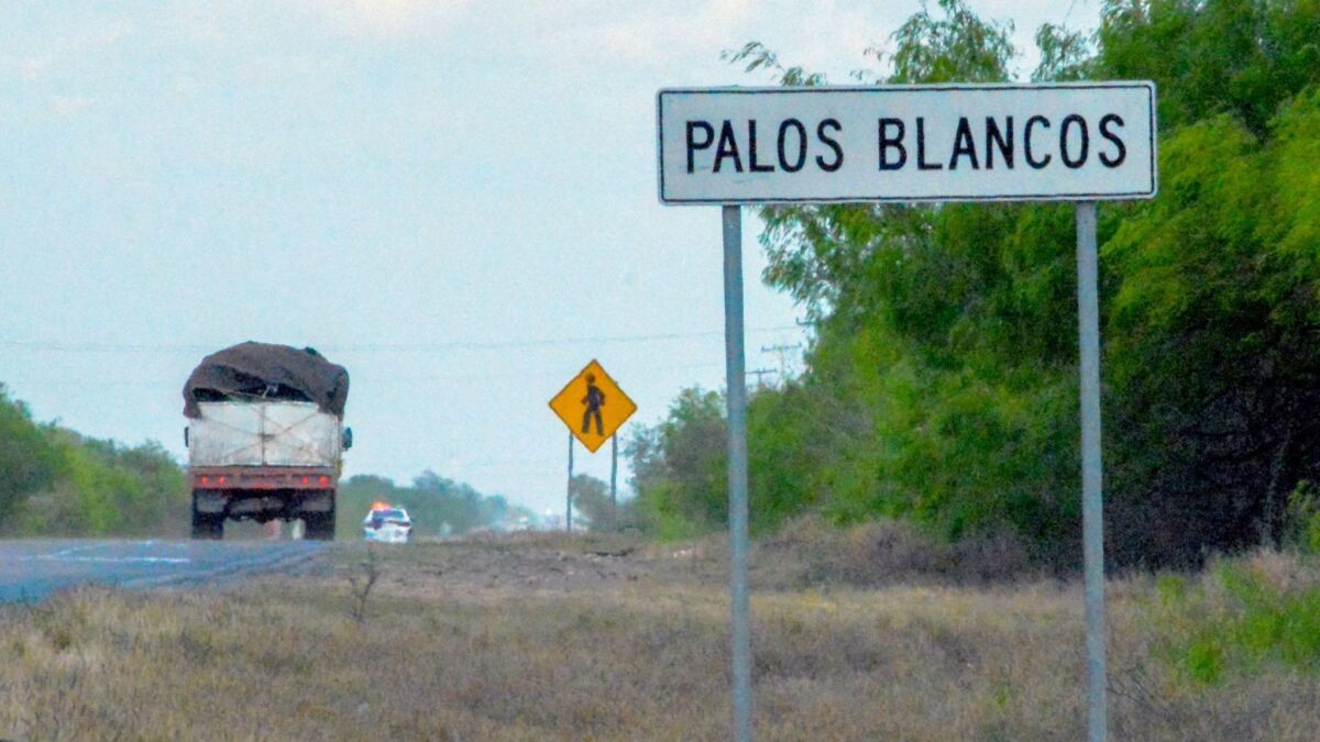 A truck passes a sign on the Reynosa-San Fernando road in the town of Palos Blancos, in Mexico's Tamaulipas state, on March, 12, 2019. At least 19 men were kidnapped from a bus passing through Palos Blancos en route to the U.S. border last week, officials said.