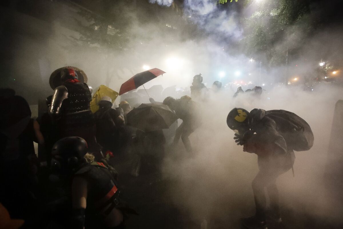 FILE - In this July 26, 2020, file photo, federal officers launch tear gas at demonstrators during a Black Lives Matter protest at the Mark O. Hatfield U.S. Courthouse in Portland, Ore. The Associated Press found that there is no government oversight of the manufacture and use of tear gas. Instead, the industry is left to regulate itself. (AP Photo/Marcio Jose Sanchez, File)