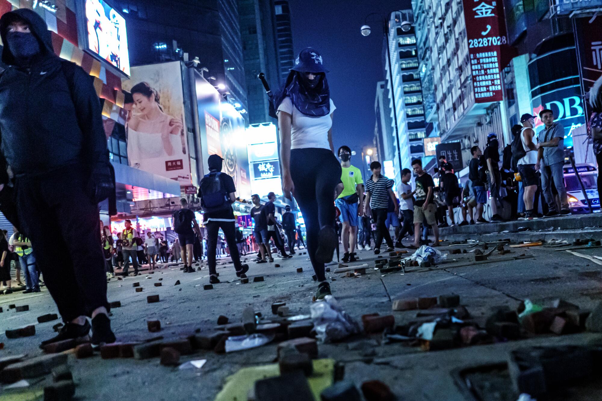 Protester spread out bricks pulled from the sidewalk as obstacles on the road on Nathan Road in the Mong Kok district of Hong Kong.