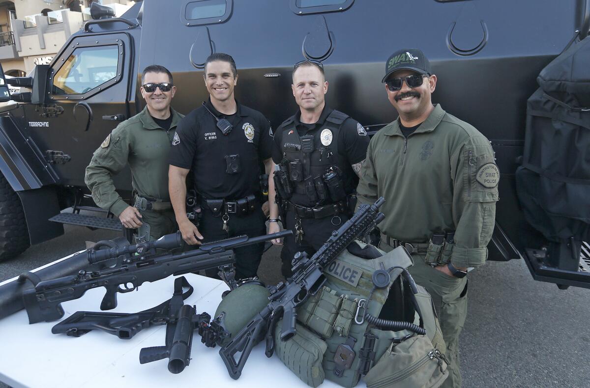 Huntington Beach Police Department officers stand next to the new SWAT team vehicle at Surf City Nights on Tuesday.