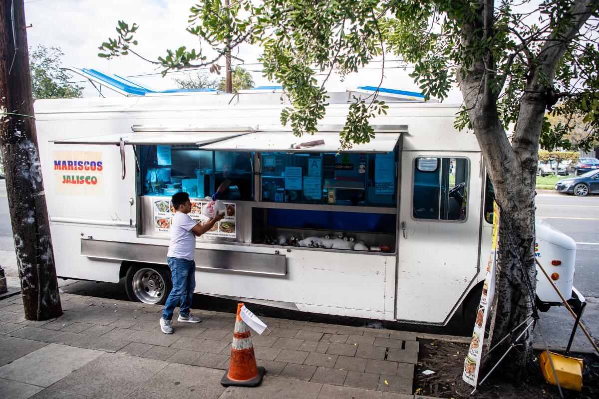 A lone customer gets his order at the Mariscos Jaliscos truck.