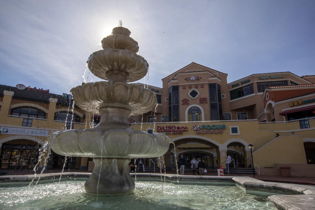 A large water fountain in front of a shopping center