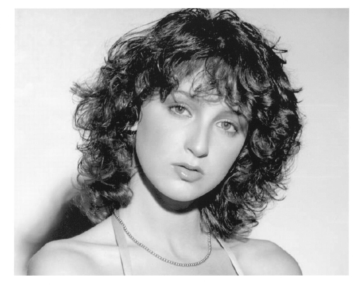 Black-and-white photo of a young woman with an '80s haircut 