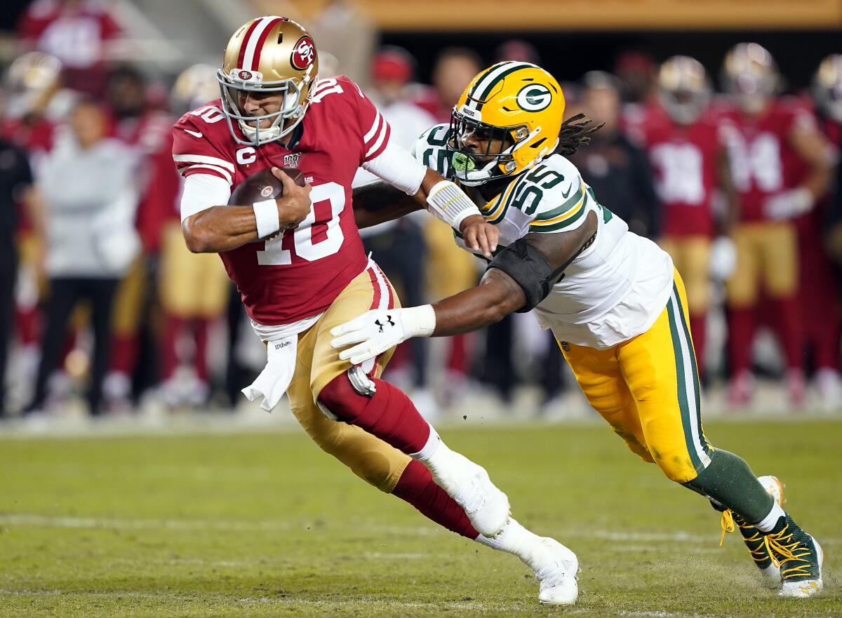 San Francisco quarterback Jimmy Garoppolo is chased by Green Bay linebacker Za'Darius Smith during the 49ers' 37-8 victory Sunday night.