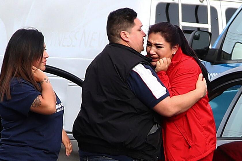 Fernando Juarez, 36, of Napa, center, embraces his 22-year-old sister Vanessa Flores, right, at the Veterans Home of California on Friday March 9, 2018. in Yountville, Calif. Flores, who is a caregiver at the facility, exchanged texts with family while sheltering in place. A gunman took at least three people hostage at the largest veterans home in the United States on Friday, leading to a lockdown of the sprawling grounds in California, authorities said. (AP Photo/Ben Margot)