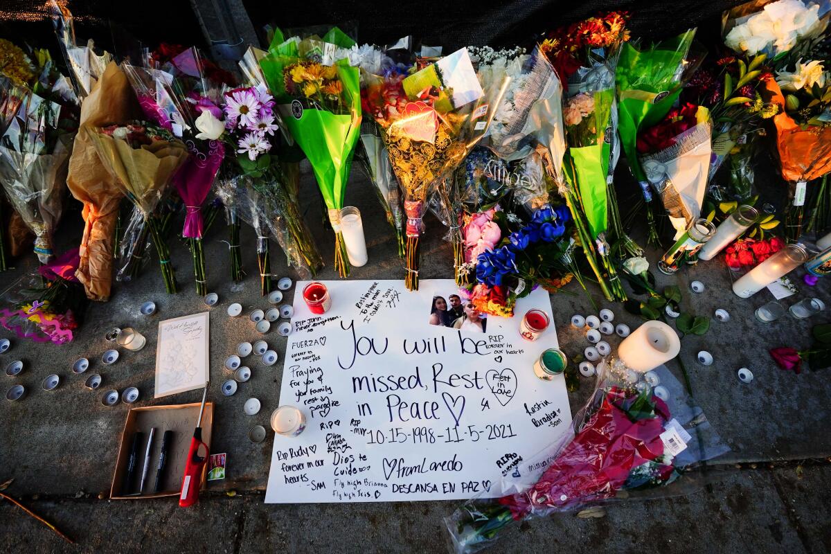 A makeshift memorial of flowers and handwritten signs.