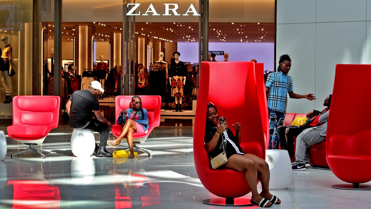 Visitors settle into modernistic custom furniture arrayed below a giant LED video screen.