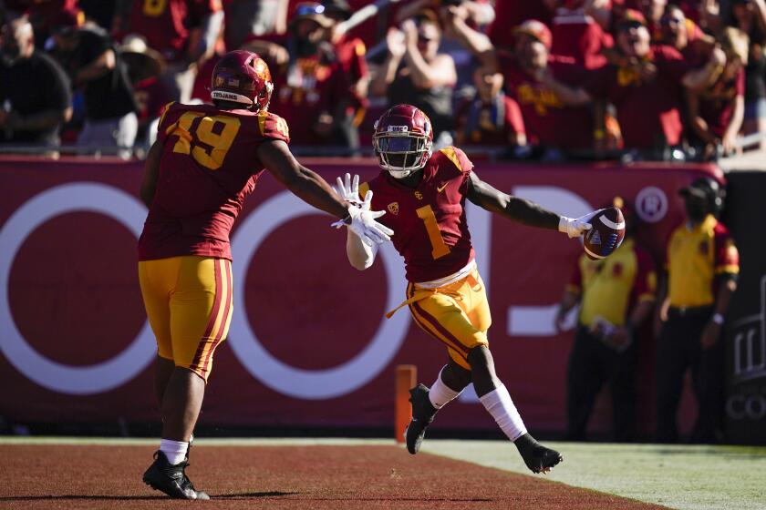 USC safety Greg Johnson, right, celebrates with defensive lineman Tuli Tuipulotu after returning an interception for a TD.